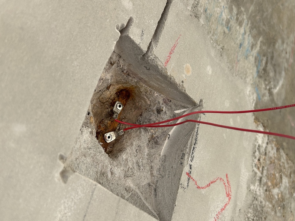 Exposed steel reinforcement with affixed cathodic protection connection wiring.